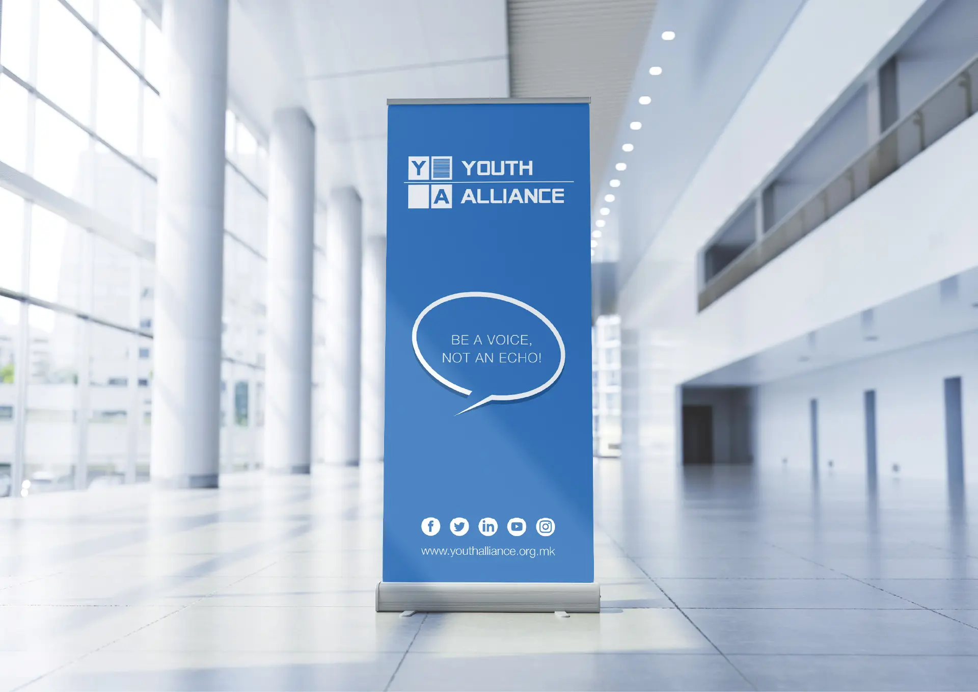 A roll-up banner with the text "Be a voice, not an echo!" inside a modern building.