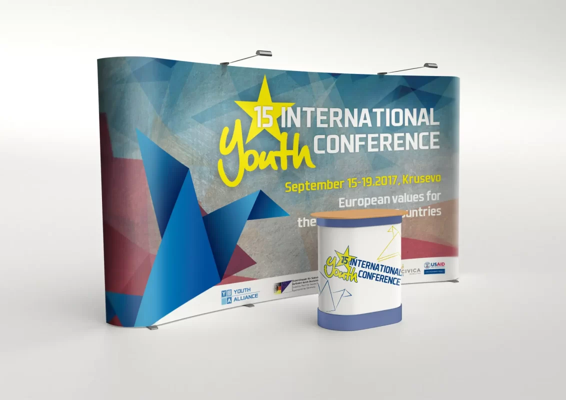 Promotional display for the 15th International Youth Conference with colorful geometric design.