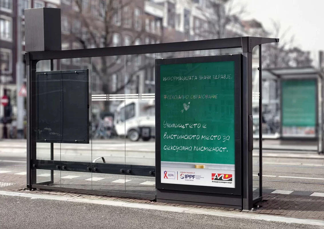 Bus stop with advertising billboard written in Cyrillic script.