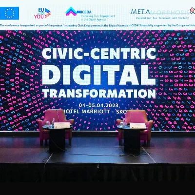 Stage setup for a 'Civic-Centric Digital Transformation' event with chairs and backdrop.