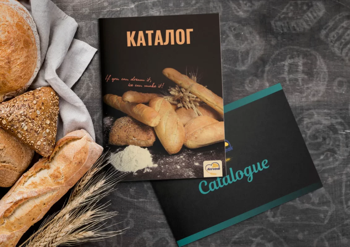 Assorted bread with a baking catalog on a textured surface. Design for Algomak.