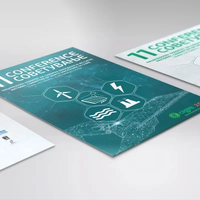 Two conference posters on a surface with geometric designs and icons related to energy and technology.