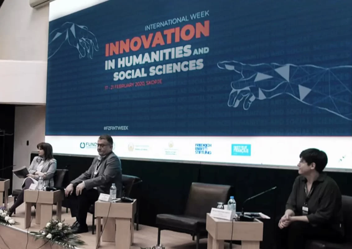 Panelists sit on stage under a banner titled 'Innovation in Humanities and Social Sciences'.