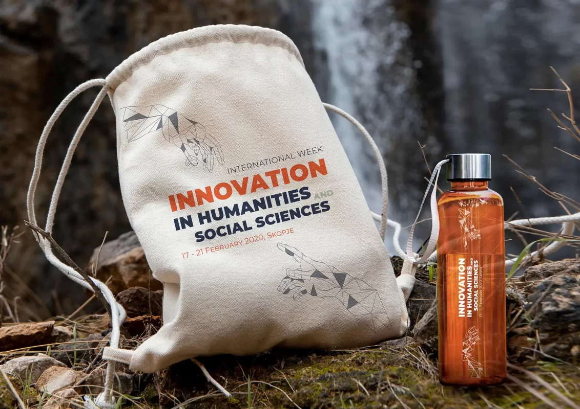 Canvas bag and water bottle with "Innovation in Humanities and Social Sciences" print, outdoor setting.