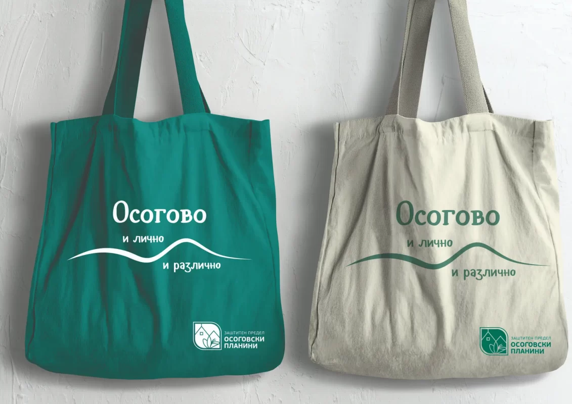 Two tote bags design with text and logos, one green and one beige, against a white wall.