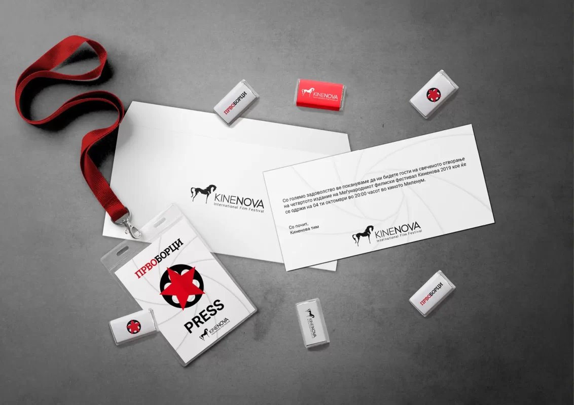 Corporate branding for a film festival with a press pass, invitation cards, and stamps on a table.