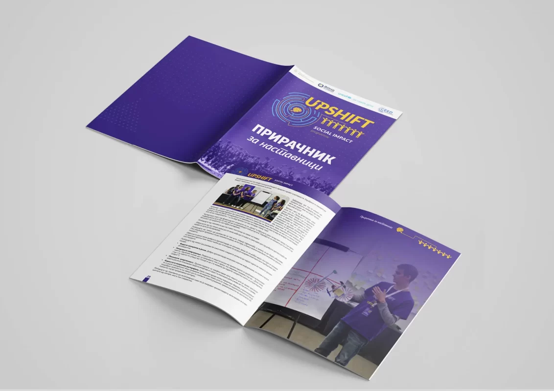 Open brochure on a desk showcasing content in purple tones with diagrams and text.